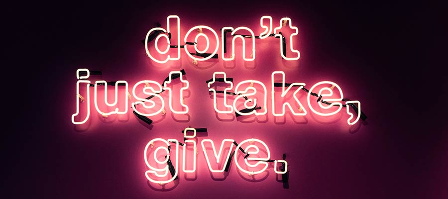 A neon sign that reads: "Don't just take, give".