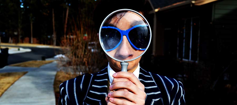A person looks through a magnifying glass.