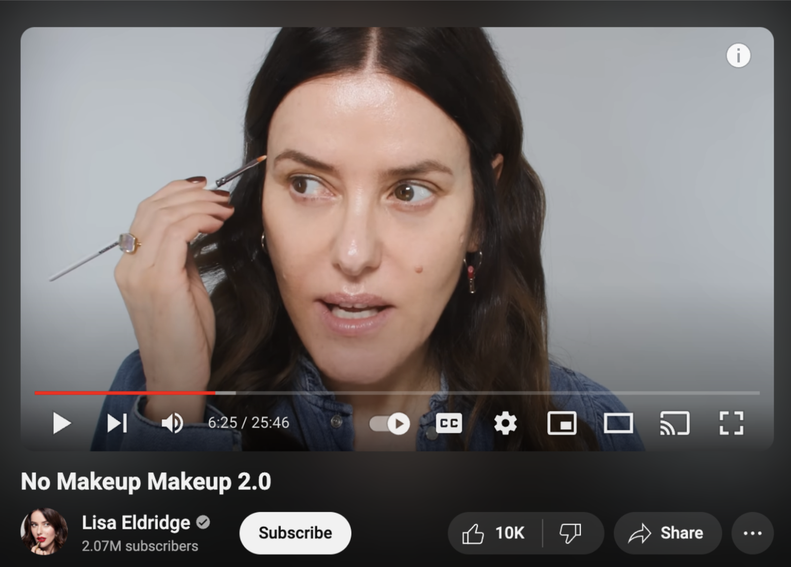 Lisa Eldridge in a YouTube tutorial holding a brow brush