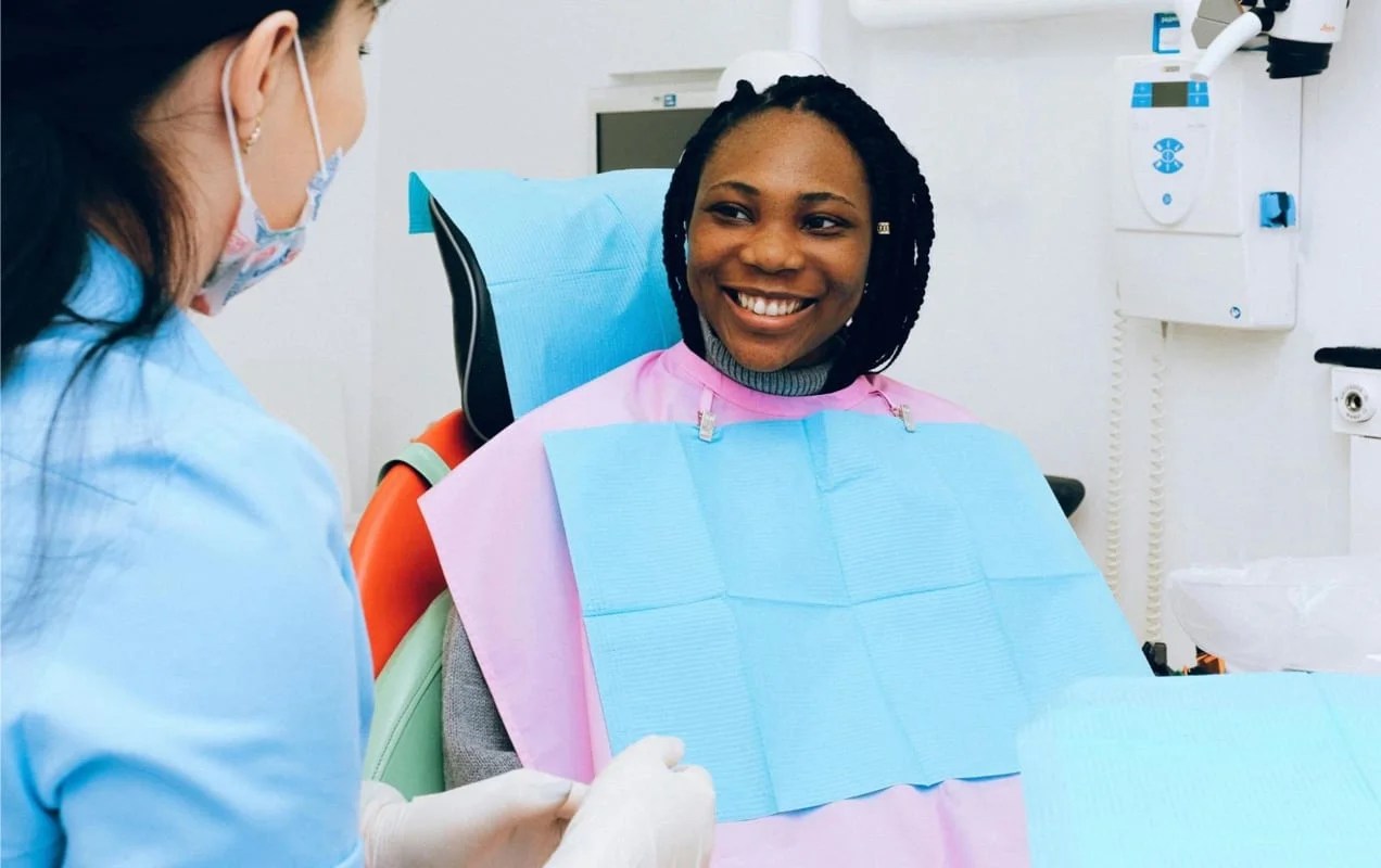 woman smiling while sitting in a dental chair