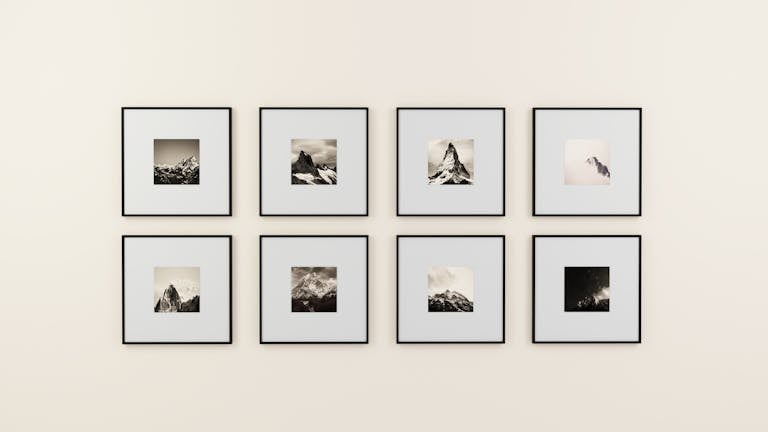 A minimalist display of framed mountain photography on a plain wall.