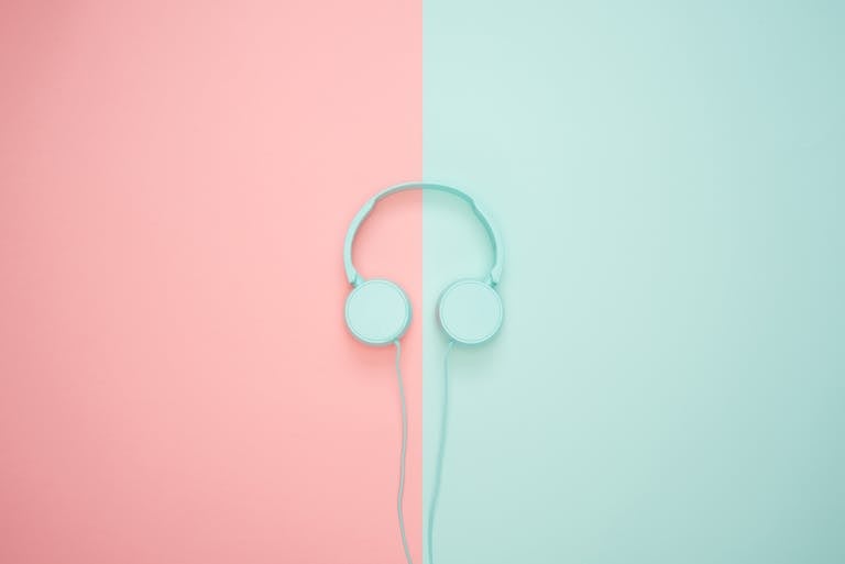 Minimalist headphones on a pink and mint background, artistic and modern.