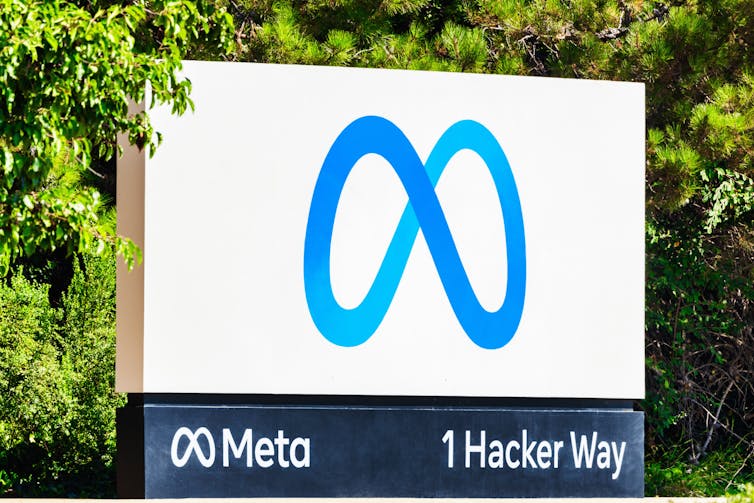 White sign with Meta's blue, figure eight-shaped logo.