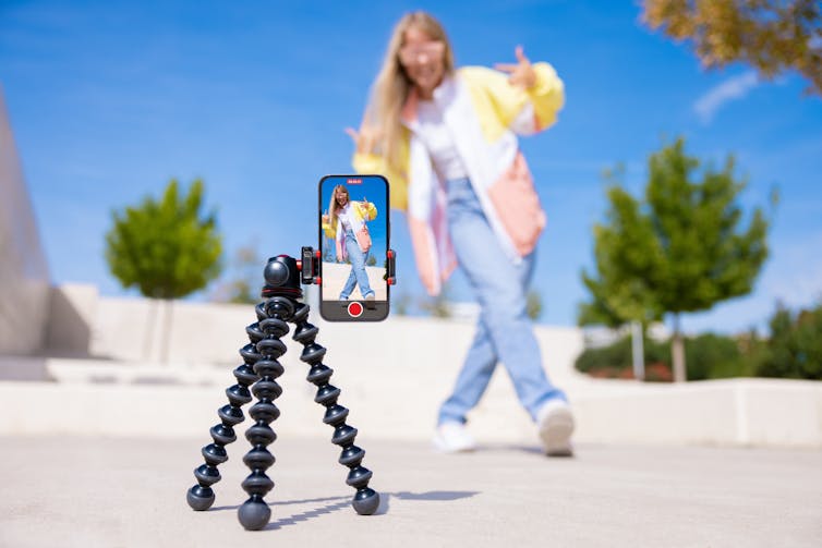 Teenage girl filming video of herself on mobile phone.