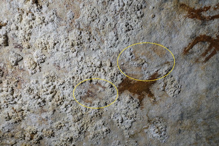 Faint outlines of a hand on a limestone rocky surface.